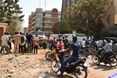 Des personnes se réunissent devant une barrière mise en place par la police près de l'hôtel Splendid à Ouagadougou le 17 janvier 2016