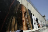 L'artiste de rue italien Jorit Agoch peint un portrait géant d'Ahed Tamimi, une adolescente palestinienne emprisonnée depuis huit mois, sur le mur construit par Israël en Cisjordanie occupée. Photo prise à Bethléem, le 25 juillet 2018