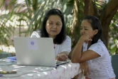 Noemia Ishikawa (g), coordinatrice du projet Linklado, explique à Cristina Quirino Mariano, de la communauté indigène ticuna, comment utiliser l'application Linklado, le 24 janvier 2024 à Manaus, dans le nord du Brésil