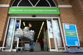 Une bénéficiaire de la banque alimentaire Trussell Trust sort avec un chariot de produits de première nécessité, le 20 janvier 2022 à Colchester, dans l'est de l'Angleterre