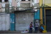 Des vendeurs de rue installés devant des boutiques fermées à Maracaibo