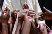 Des enfants touchent la main du pape François qui visite un camp de réfugiés à Bangui le 29 novembre 2015