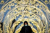 Un homme portant un masque médical pour se protéger contre le coronavirus marche parmi les décorations de Noël près de la Cathédrale du Christ-Sauveur dans le centre de Moscou, le 18 décembre 2020