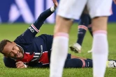L'attaquant brésilien du Paris Saint-Germain, Neymar, se tord de douleur après un violent tacle de son compatriote de Lyon, le milieu de terrain Thiago Mendes, lors de leur match de L1, 1e 13 décembre 2020 au Parc des Princes