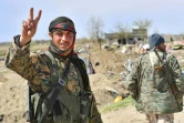 Un combattant des Forces démocratiques syriennes (FDS) fait le V de la victoire le 23 mars 2019 près du champ pétrolier d'Al-Omar, dans l'est de la Syrie, après l'annonce de la chute du "califat" du groupe Etat islamique (EI)