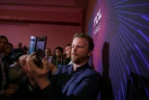 A man uses a new TCL 10 series phone at the TCL news event during the 2020 Consumer Electronics Show (CES) in Las Vegas