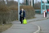 Une femme âgée ukrainienne se repose quelques instants, après avoir franchi la frontière avec la Hongrie, à Tiszabecs, le 27 février 2022