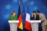 Le président français Emmanuel Macron, informé de la prise d'otages à Trèbes, pendant une conférence de presse avec la chancelière allemande Angela Merkel à Bruxelles le 23 mars 2018