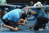 Des membres de l'organisation réparent le filet cassé par un service puissant de Naomi Osaka à l'Open d'Australie, le 20 janvier 2020 à Melbourne