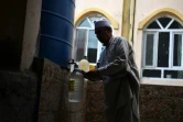 Un Afghan remplit d'eau des bouteilles en plastique au robinet d'une citerne, le 25 octobre 2018 à Kaboul