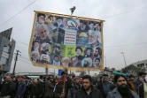 Des partisans du Hachd al-Chaabi, coalition de factions irakiennes pro-Iran, manifestant dans les rues de Bagdad le 2 janvier 2022 avec une pancarte où il est notamment écrit "Mort à l'Amérique"