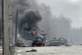 Un blindé en feu et le corps d'un soldat dans une rue de Kharkiv, seconde ville ukrainienne, le 27 février 2022
