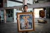 L'artiste thaïlandais Chalermpol Junrayab montre l'une de ses oeuvres exposées à la galerie Lhong 1919, le 16 novembre 2020 à Bangkok