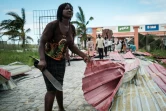 Une femme récupère des tôles pour reconstruire sa maison détruite par le cyclone Idai à Beira, au Mozambique le 21 mars 2019