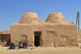 Une famille assise devant sa maison enterre traditionnelle à coupole, au village de Haqla, le 11 août 2023 en Syrie