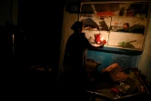 Une femme s'éclaire à la bougie pendant une coupure de courant, le 30 mrs 2022 à Colombo, au Sri Lanka