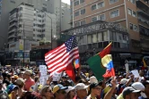 Un drapeau américain brandi par des partisans du chef de l'opposition vénézuélienne Juan Guaido qui se rassemblent le 12 février 2019 dans l'est de Caracas pour faire pression sur l'armée afin qu'elle laisse entrer l'aide humanitaire américaine