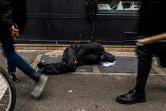 Un sans-abri est allongé sur un conduit de chauffage le 8 janvier 2024 dans le centre de Paris