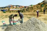 Des réfugiés rohingyas remplissent des sacs avec du sable lors de préparatifs avant l'arrivée de la mousson, le 7 mai 2018 au camp de Kutupalong, au Bangladesh