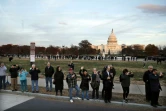 Des gens regardent le passage du corbillard transportant la dépouille du 41e président des Etats-Unis, George Herbert Walker Bush, à Washington le 3 décembre 2018