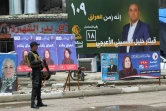 Un policier irakien à un check-point devant des affiches électorales, le 11 mai 2018 à Mossoul, en Irak