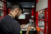 Fouad Choaibi répare des smartphones dans une ancienne cabine téléphonique à Londres, le 20 octobre 2017