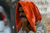 Un homme couvre sa tête d'un tissu pour se protéger de la chaleur lors d'une chaude journée d'été, le 28 avril 2022 à New Delhi, en Inde