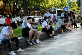 Des habitants assis dans une rue de Pékin attendent de dîner à la terrasse d'un restaurant, le 6 juin 2022