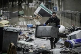 Un habitant ramasse les débris dans une rue inondée de Villeneuve-Saint-Georges le 25 janvier 2018