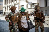 Des membres des forces de défense escortent un sans-abri à Johannesburg vers un centre de rassemblement, le 27 mars 2020