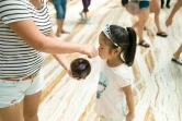 Une enfant boit dans une fausse noix de coco dans le "New Century Global Center" de Chengdu, la capitale du Sichuan, le 25 juillet 2016