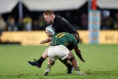 Le pilier néo-zélandais Fletcher Newell tente de résister au plaquage du Sud-Africain Makazole Mapimpi, le 13 août 2022 à Johannesburg 