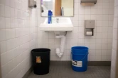 Un seau d'eau dans les toilettes de l'école Wilkins pour remplacer les chasses d'eau le 23 mars 2022