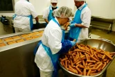 Des employés du constructeur automobile allemand Volkswagen emballent des saucisses au curry produites au siège de l'entreprise à Wolfsburg en Allemagne le 21 avril 2016