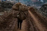 Un homme récupère des déchets peu après l'effondrement d'une décharge à Kampala, en Ouganda, le 10 août 2024