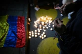 Un homme tient un crucifix pendant qu'il prie devant la clinique où le sénateur Miguel Uribe est hospitalisé après avoir été blessé par balle, à Bogota, le 7 juin 2025