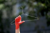 Une défenseure du droit à l'avortement brandit un ceintre, symbole des avortements clandestins, lors d'un défilé à Marseille, le 2 juillet 2022