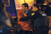Un policier console une parente d'une des victimes de l'attaque contre un bus de la garde présidentielle à Tunis le 24 novembre 2015