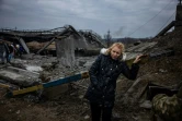 Une femme prend un peu de repos après avoir traversé un pont déruit pour quitter la ville d'Irpin, au nord-ouest de Kiev, le 7 mars 2022