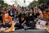 es partisans de Move Forward font le salut à trois doigts devant le Monument de la Démocratie, lors d'un rassemblement après le rejet définitif par le Parlement de la candidature de Pita Limjaroenrat au poste de Premier ministre, le 19 juillet 2023 à Bangkok, en Thaïlande
