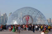 Des personnes rassemblées près de l'horloge marquant le compte à rebours avant la Coupe du monde de football, à Doha au Qatar, le 30 mars 2022