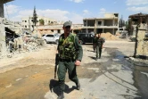 Photo obtenue auprès de l'agence officielle syrienne SANA le 15 avril 2018 montrant des membres des forces du régime dans Douma après le départ des derniers combattants rebelles de la ville