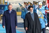 Le président turc Recep Tayyip Erdogan (g) et son homologue iranien Ebrahim Raïssi passent en revue la garde d'honneur, le 24 janvier 2024 à Ankara