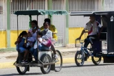 Une famille à bord d'un vélo-taxi le 29 juillet 2021 à Maracaibo, au Venezuela