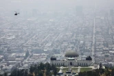 Un hélicoptère survole l'observatoire Griffith à Los Angeles, Californie, alors qu&rsquo;un nuage de pollution opacifie la ville, le 5 juillet 2019