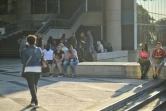 Un groupe de personnes devant un immeuble de bureaux et de commerces, le 30 août 2024 à Caracas, en pleine panne d'électricité. 