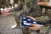 Un soldat américain tient le drapeau américain lors d'une cérémonie de passation au camp Leatherneck, le 28 avril 2017 dans la province afghane du Helmand