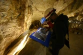 Des employés regardent des photos de la grotte Cosquer sur le site de la réplique à la villa Méditerranée, le 23 novembre 2021
