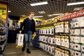 Un client apporte sa PlayStation 5 qu'il vient d'acheter dans un magasin d'électronique à Sydney, le 12 novembre 2020