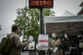 Des bénévoles distribuent des masques le 30 avril 2020 à l'extérieur d'une station de métro à Vincennes, en banlieue parisienne